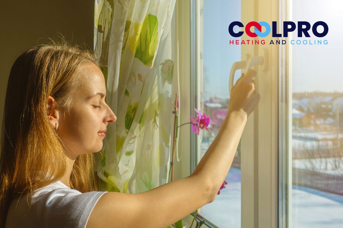 A woman opening a window with the words colpro heating and cooling.