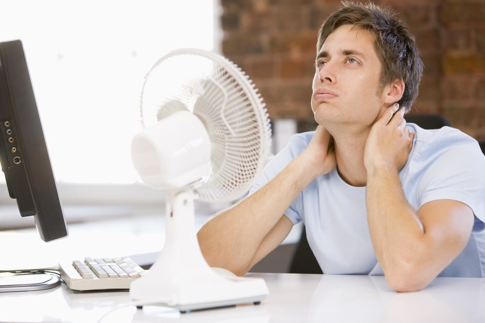 Man sitting in front of fan Air Conditioner Troubleshooting