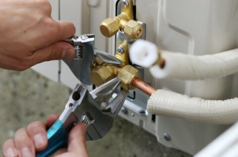 A person is working on a hot water heater.