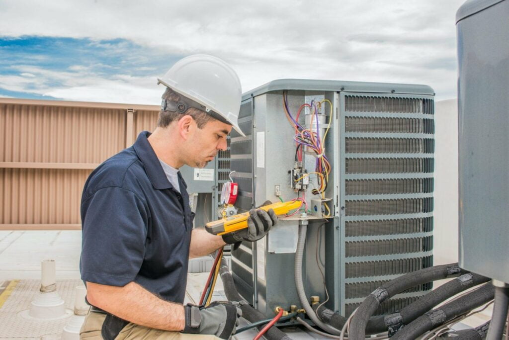 A man working on an air conditioning unit.