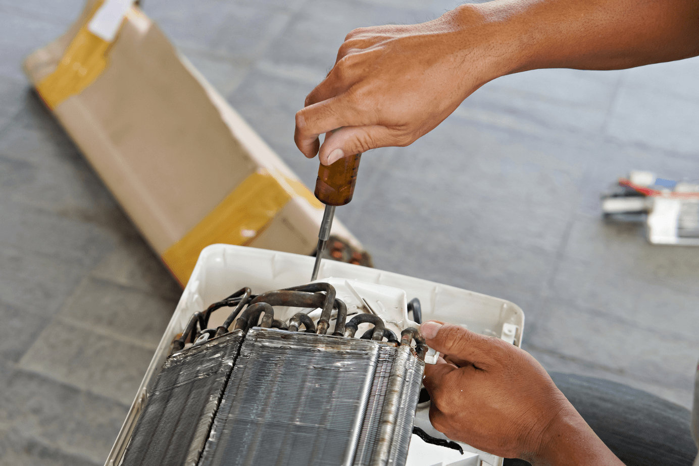 A man is working on an air conditioning unit.