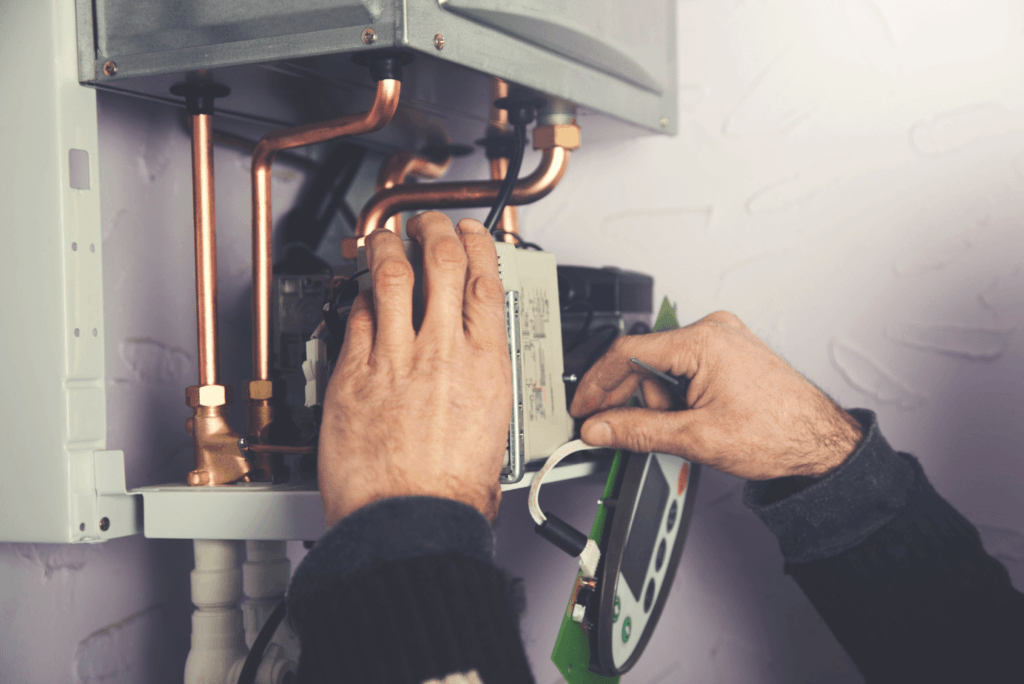 A man is working on a hot water heater.