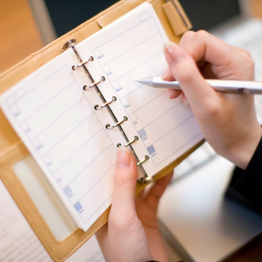 A person writing on a calendar following step 1 of scheduling service with Coolpro hvac company.