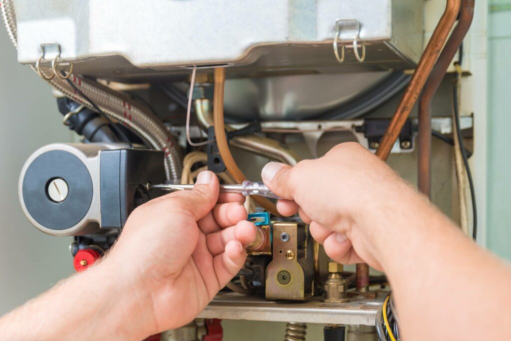 A technician performing furnace repair on a gas furnace.