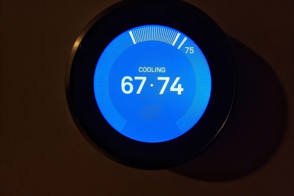 A wireless thermostat is displayed on a wall.