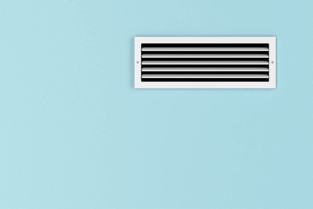 Signs you need to change your home air filter: a white air conditioner on a blue wall.