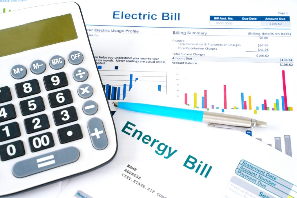 A calculator sits on top of a sheet of paper with the words energy bill, indicating signs you need to change your home air filter.