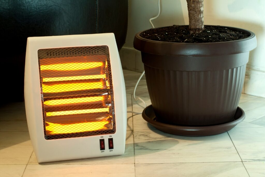 A space heater placed near a potted plant, following safety tips.