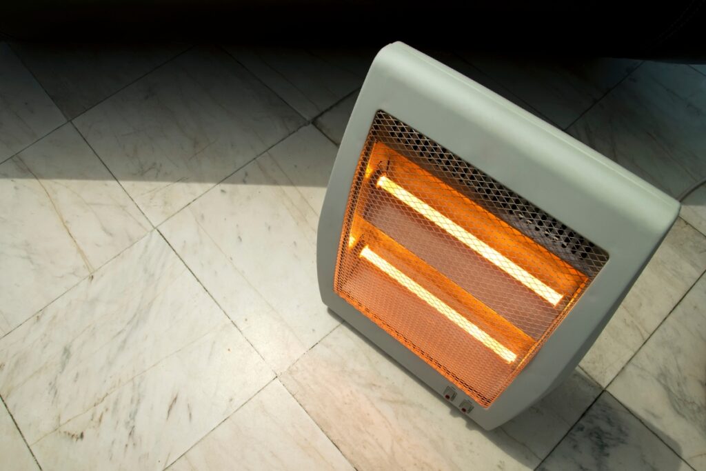 A space heater sitting on a tile floor.