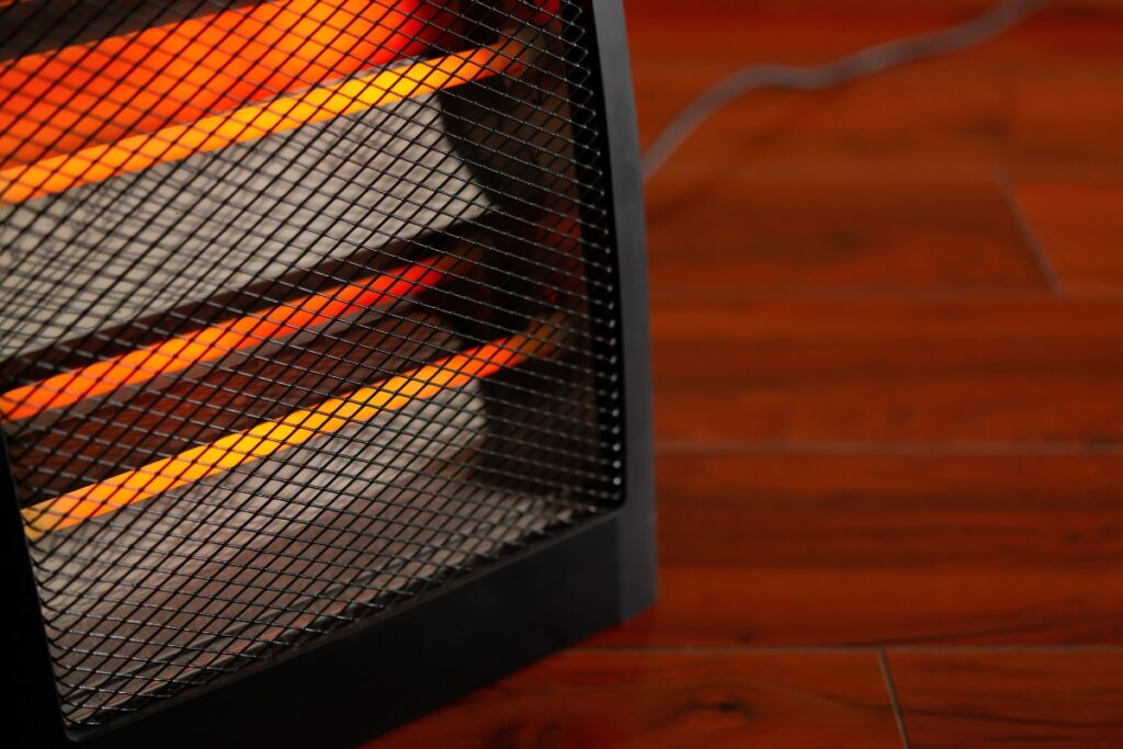 A space heater sitting on a wooden floor, adhering to safety tips.