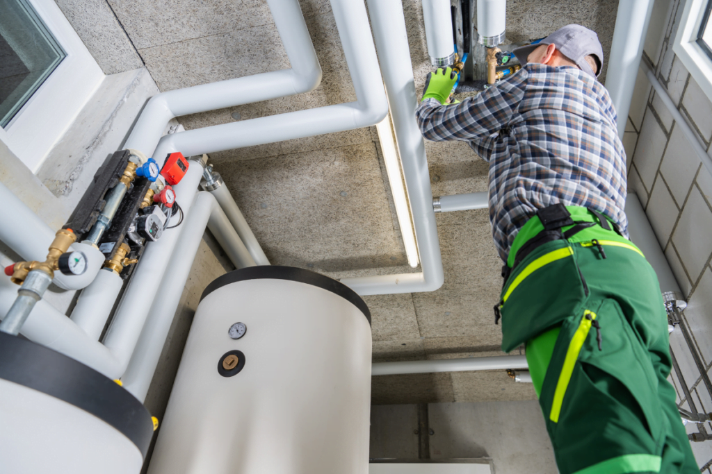 A technician working on an HVAC system in a building.