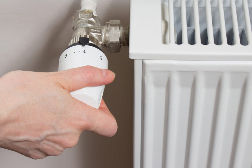 A hand is holding a thermostat for effective temperature regulation.