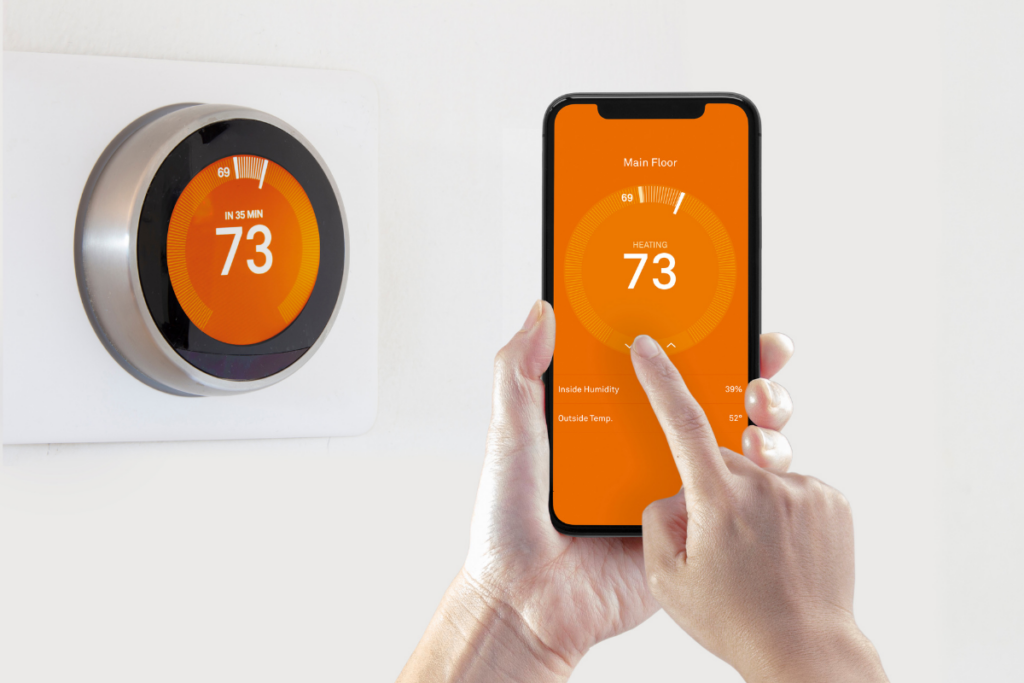 A person holding her phone showing how smart thermostats work.