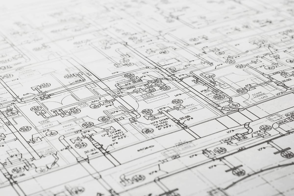 Close-up view of architectural blueprints showing detailed plans, technical specifications, and types of HVAC systems integrated into the design.