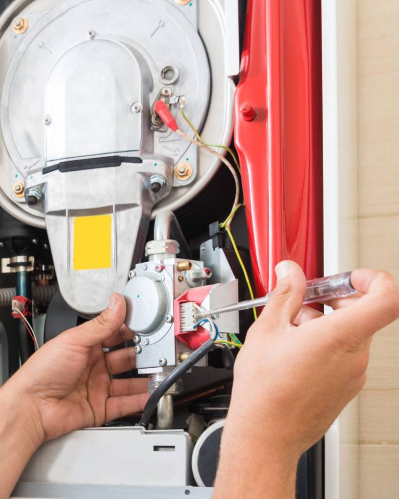 A man conducting furnace repair in a bathroom.