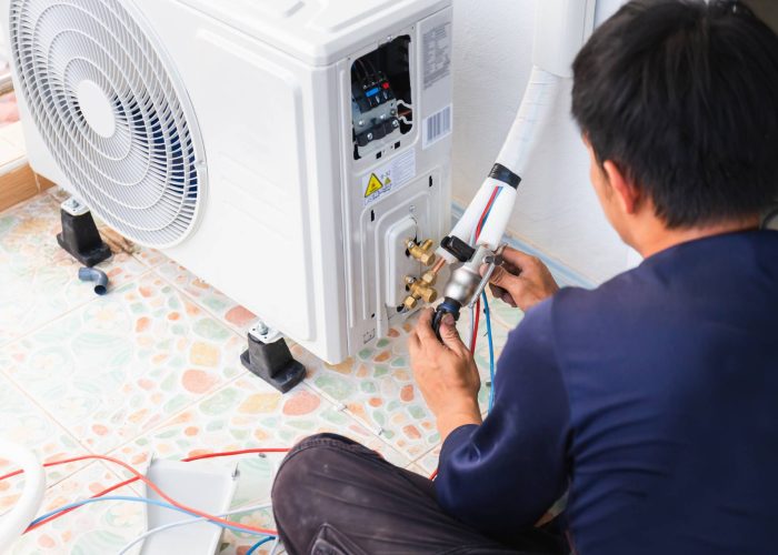 A man is repairing a air conditioner. A man is repairing a air conditioner.