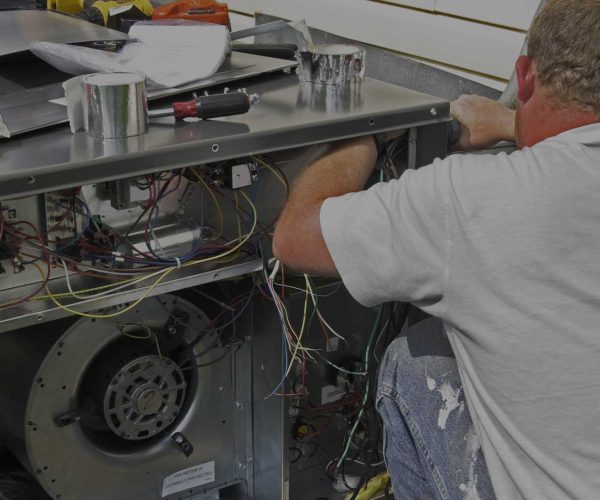 A man is working on an air conditioning unit.