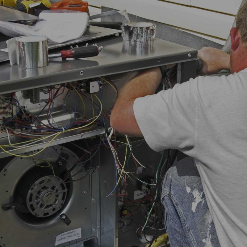 A man is working on an air conditioning unit.